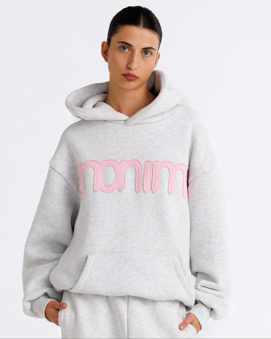 Person wearing a gray hoodie with pink text on a white background