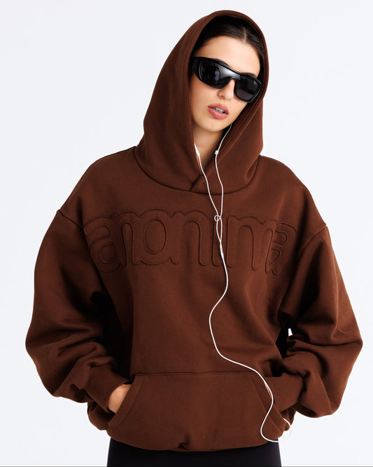 Person wearing a brown hoodie with 'Supreme' branding on a white background