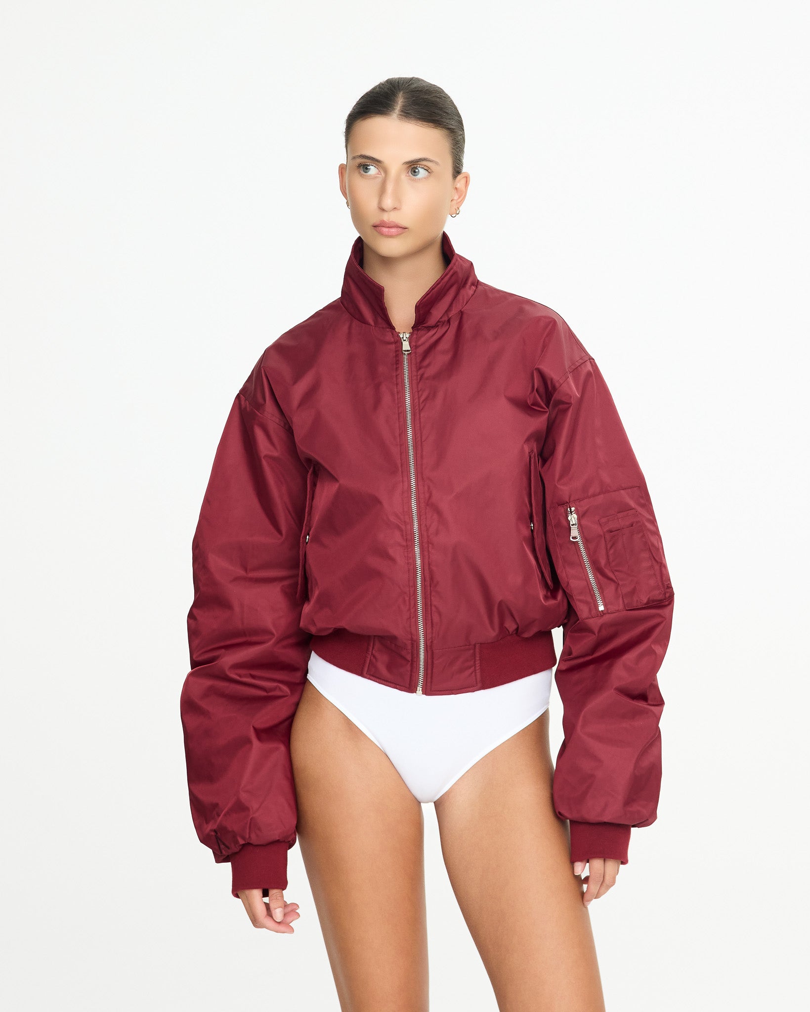 Person wearing a red jacket over a white swimsuit on a white background