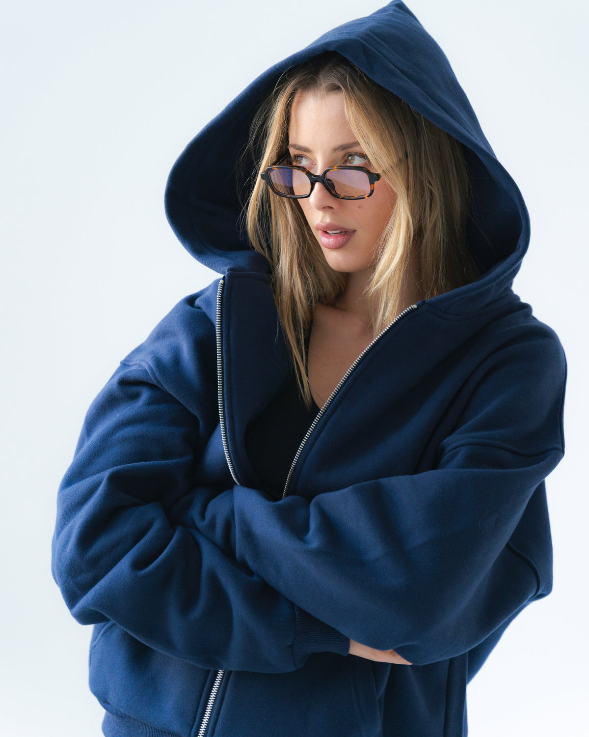 Person wearing a blue hoodie on a light gray background